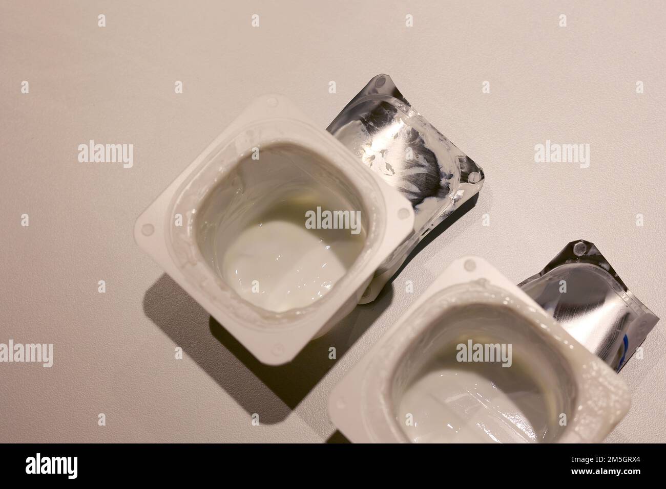 Svuotare i vasetti dello yogurt con i coperchi Foto Stock