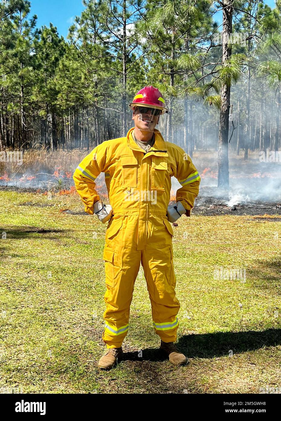 Fort Stewart-Hunter Army Airfield Garrison Commander, col. Manny Ramirez, deck out in attrezzatura protettiva antincendio, si trova tra le fiamme che ha creato utilizzando la torcia di terra del Forestry Branch, un dispositivo utilizzato in combinazione con una caduta aerea per creare e controllare le ustioni prescritte in tutte le aree di addestramento dell'installazione. per comprendere meglio la loro missione e raggiungere la conformità. L'installazione prescrive ordinariamente ustioni da 100.000 a 120.000 acri all'anno per fornire spazio di addestramento per i soldati stazionati qui ed altri servizi del Dipartimento della Difesa. Foto Stock