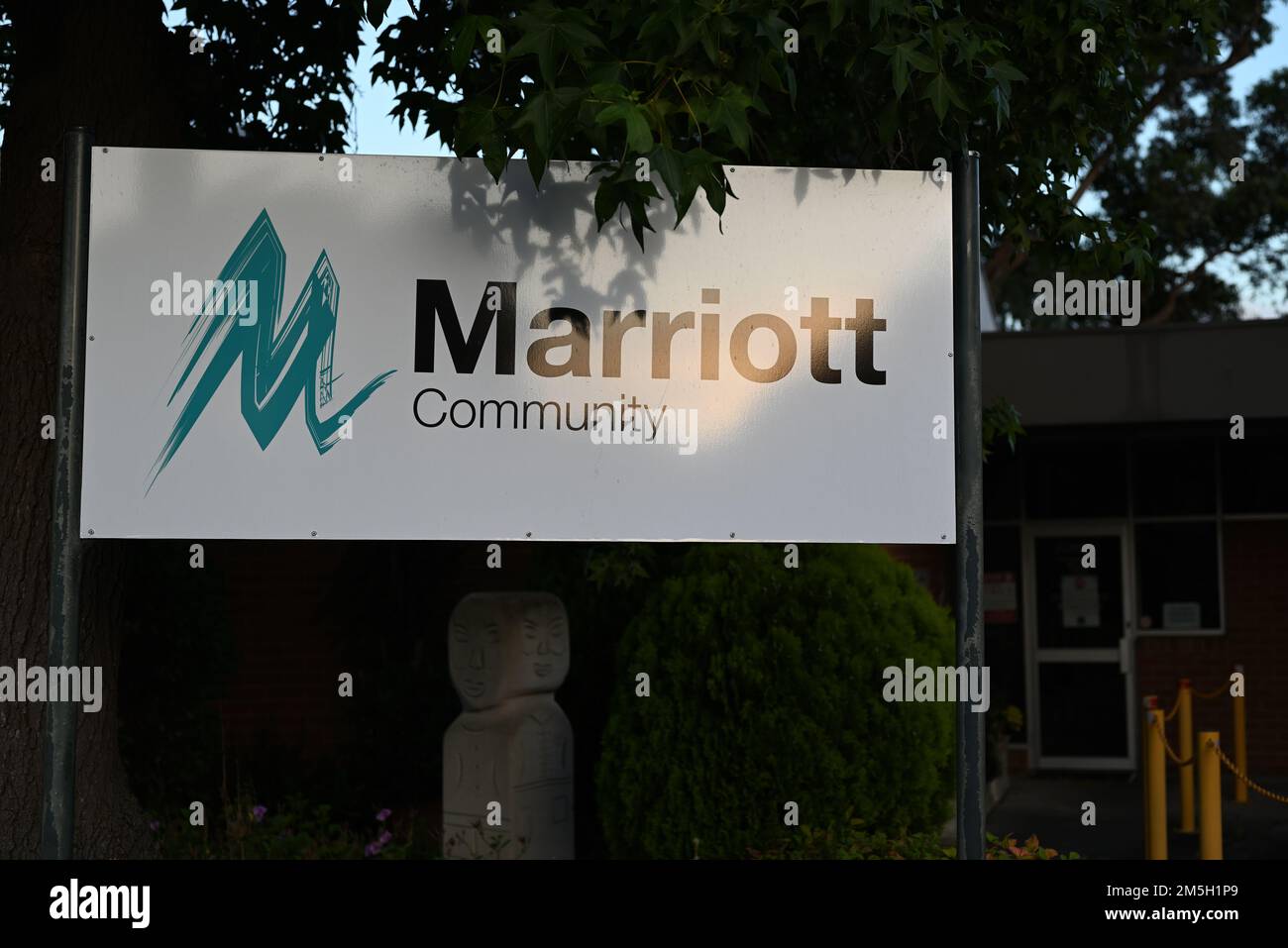 Simbolo della comunità Marriott, all'esterno dell'hub Wheatley Rd dell'organizzazione dei servizi di assistenza ai disabili, con una scultura distintiva sullo sfondo Foto Stock
