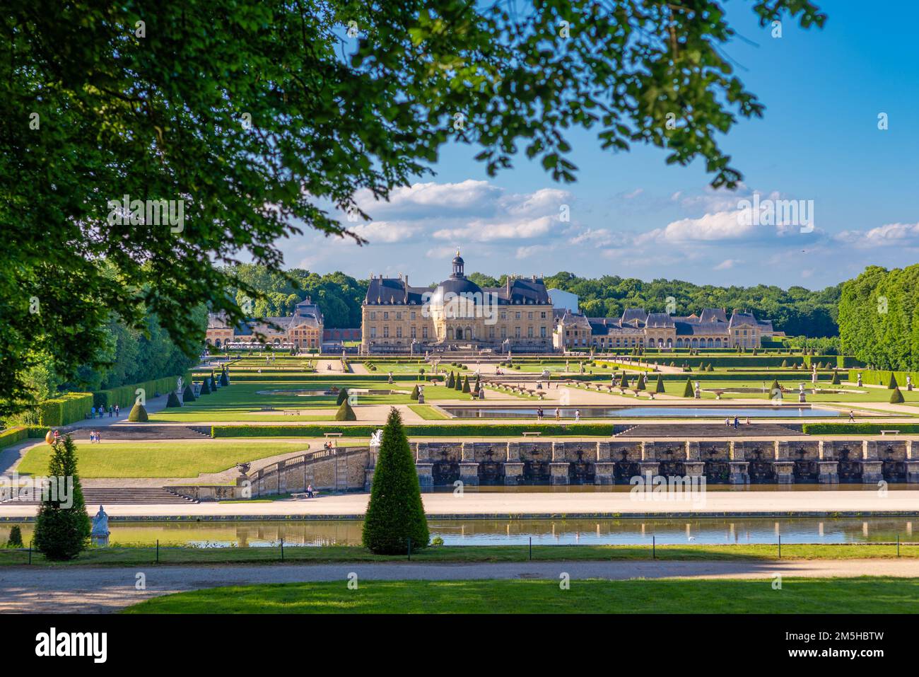 Maincy, Francia - 21 maggio 2022: Un castello si pone sulla prospettiva principale di un giardino classico francese (Vaux-le-Vicomte). Foto scattata in un su di inizio estate Foto Stock