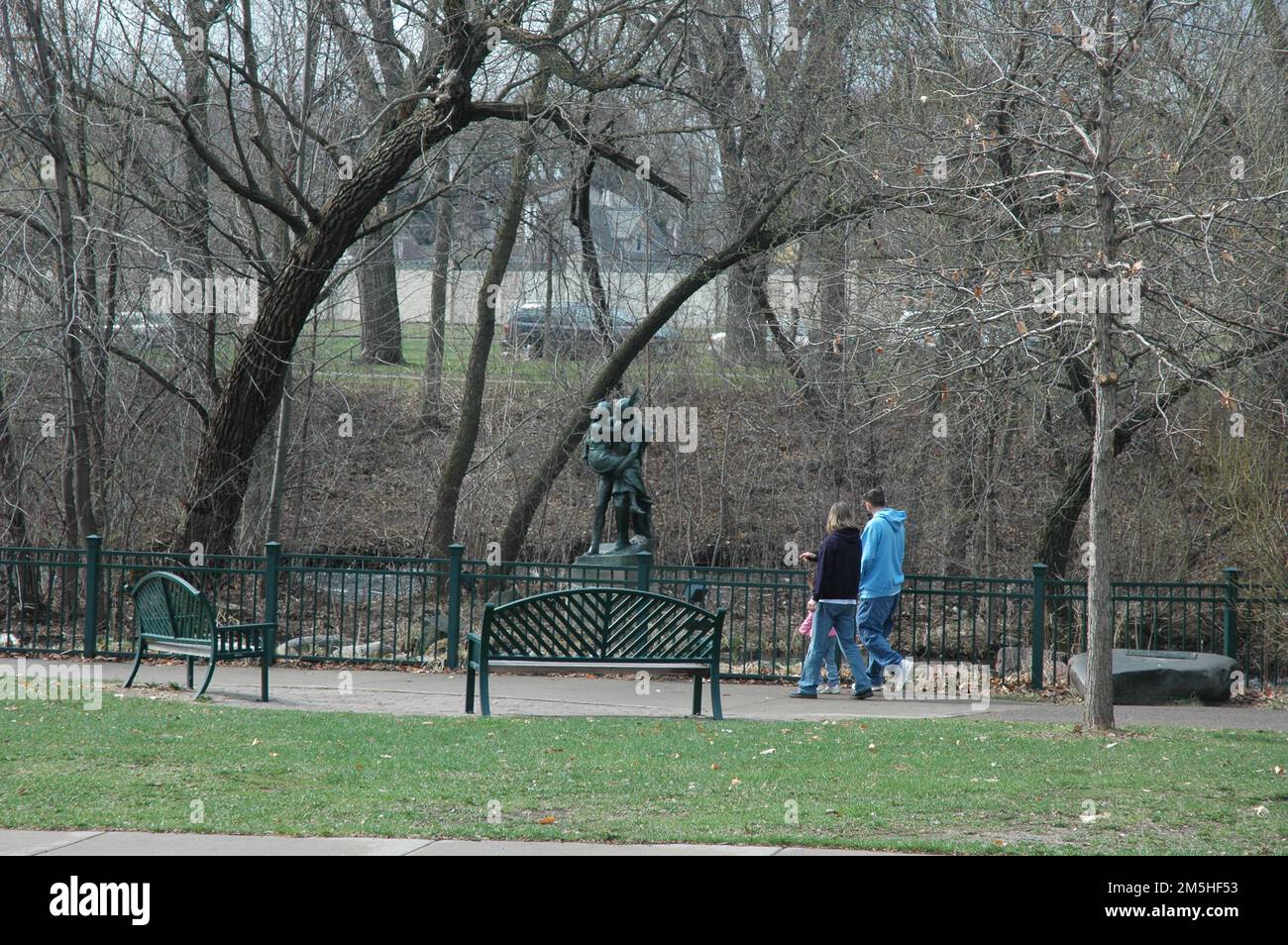 Grand Rounds Scenic Byway - visitatori di Hiawatha e della Statua di Minnehaha. Una famiglia passa davanti all'Hiawatha e alla statua di Minnehaha una mattina di aprile nel Minnehaha Park di Minneapolis. Minnehaha Park, Minneapolis, Minnesota (44,915° N 93,210° W) Foto Stock