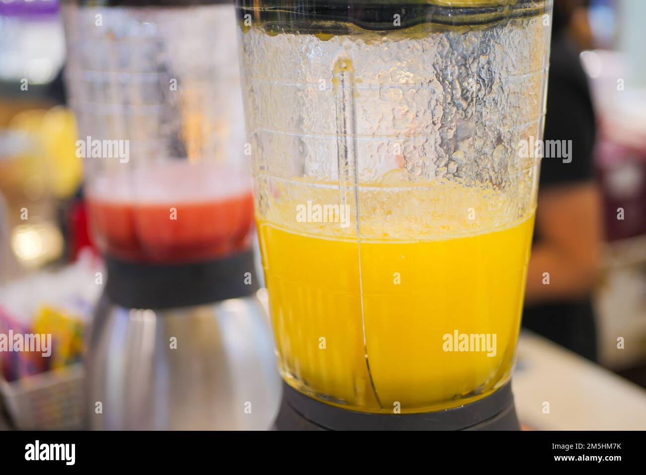 Frullare con succo e frutta fresca sul tavolo Foto Stock