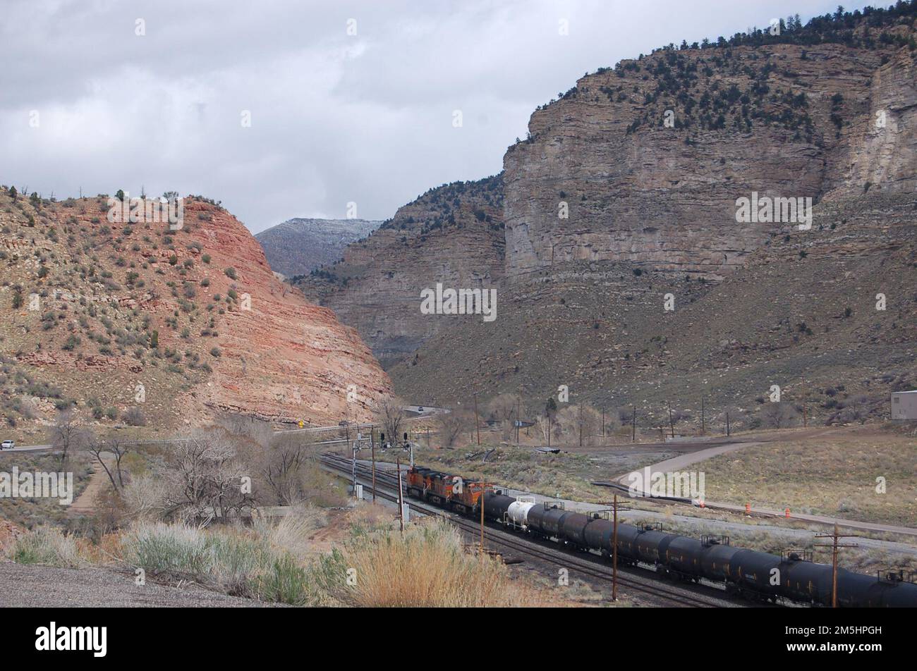 Dinosaur Diamond Prehistoric Highway - treno che passa attraverso Castle Gate. Un treno si allontana sotto la Route 6 mentre si avvicina a un punto stretto nel Barn Canyon lungo il fiume Price. Ubicazione: Castle Gate, a nord-ovest di Helper, Utah (39,747° N 110,884° W) Foto Stock