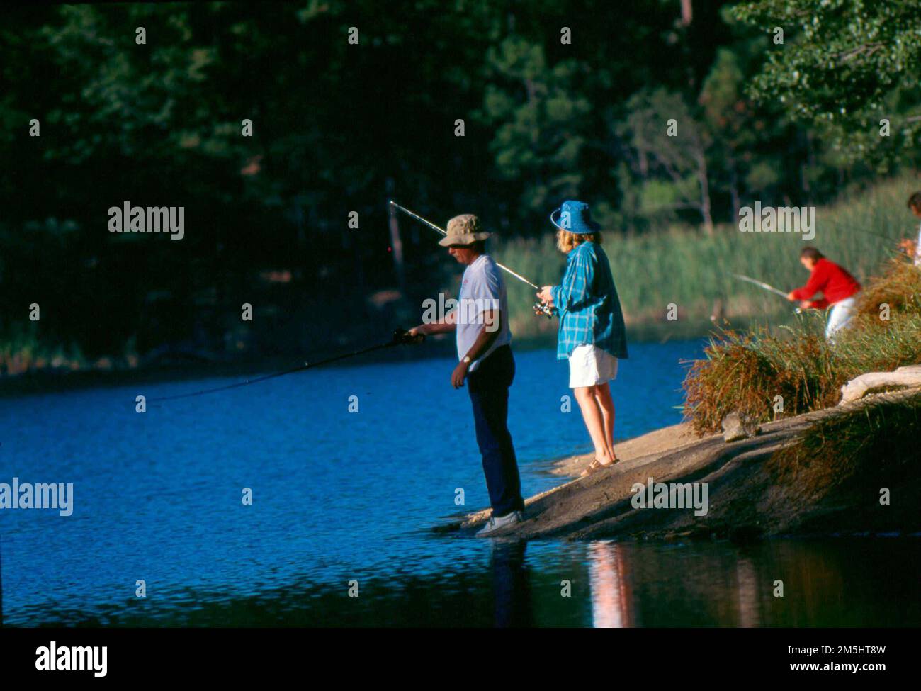 Sky Island Scenic Byway - pesca al Lago Rose Canyon. Pescatori e donne guardano le acque scure del Lago Rose Canyon mentre aspettano di agire alla fine delle loro linee di pesca. Il lago Rose Canyon è un luogo popolare dove fare escursioni lungo il sentiero lungo la riva del lago o pescare trote. Location: Italy (32,387° N 110,711° W) Foto Stock