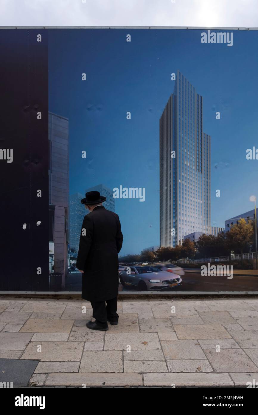 Un ebreo ultra ortodosso vede un grande poster che promuove il progetto immobiliare a Gerusalemme ovest Israele Foto Stock