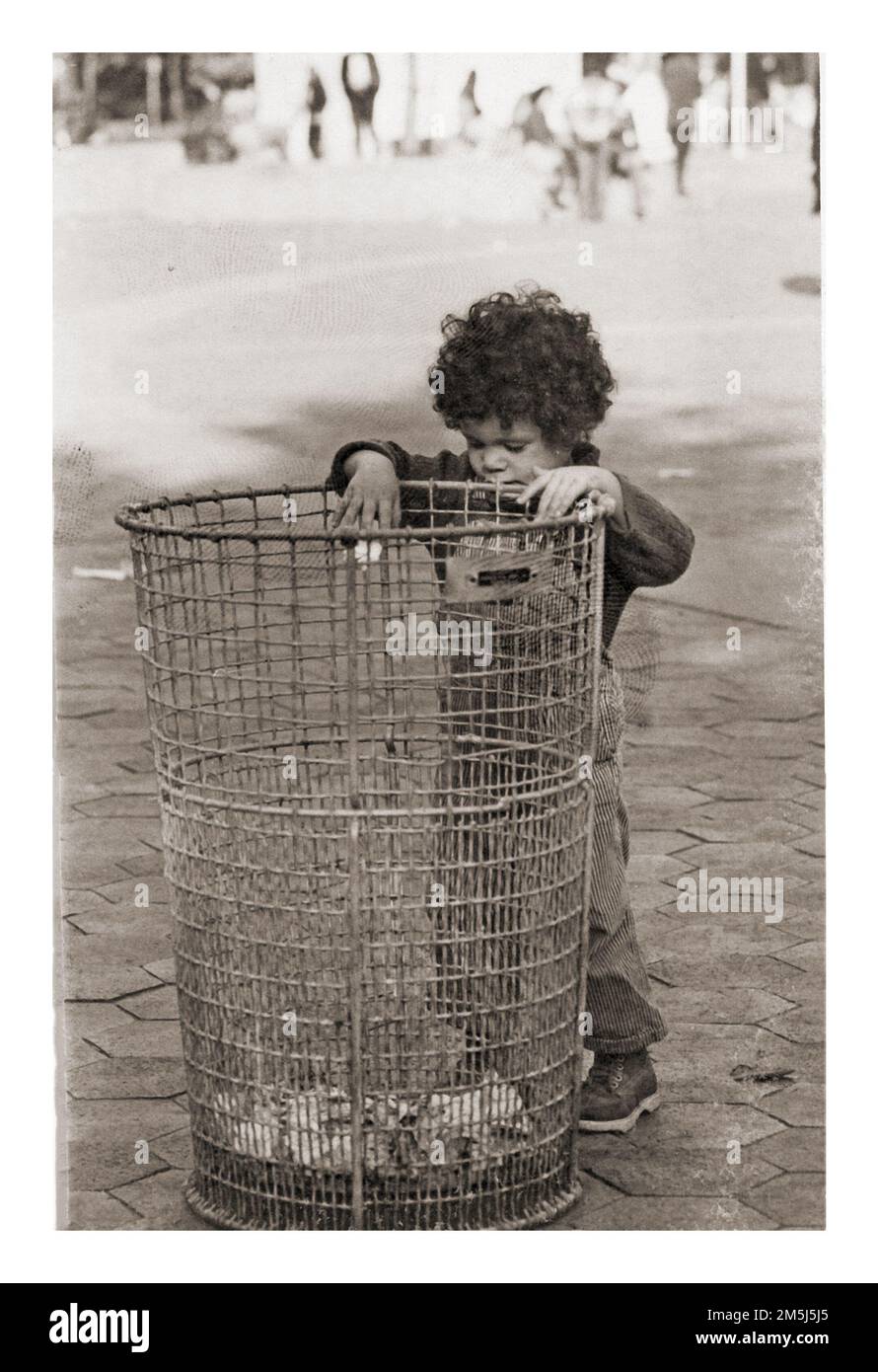 Un giovane ragazzo lancia un po' di spazzatura in una spazzatura può. Nel Washington Square Park di manhattan, circa 1974. Foto Stock
