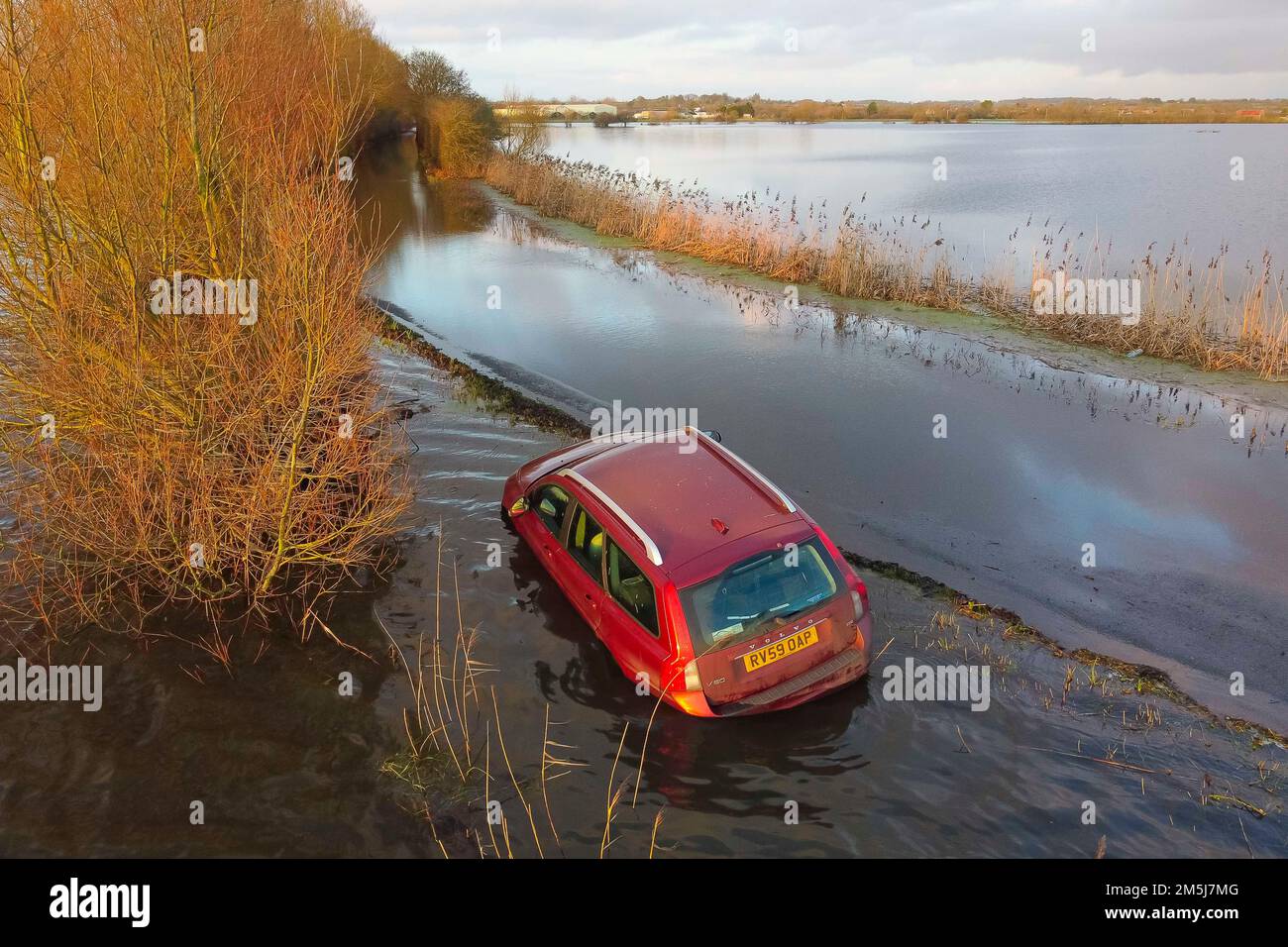 Muchelney Somerset, Regno Unito. 29th dicembre 2022. Meteo nel Regno Unito. Un'auto è bloccata in inondazioni sulla strada tra Muchelney e Langport nel Somerset dopo che il fiume Parrett ha scoppiato le sue rive inondando i campi e la strada dopo una forte pioggia. Picture Credit: Graham Hunt/Alamy Live News Foto Stock