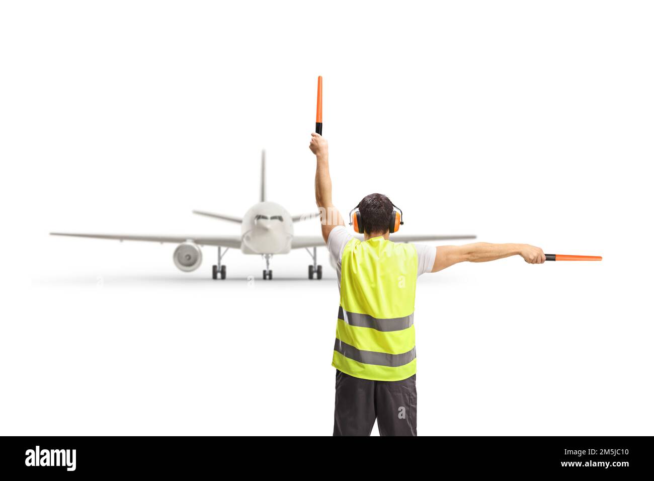 Immagine posteriore di un marshaller che segnala con le bacchette davanti ad un aeroplano isolato su sfondo bianco Foto Stock