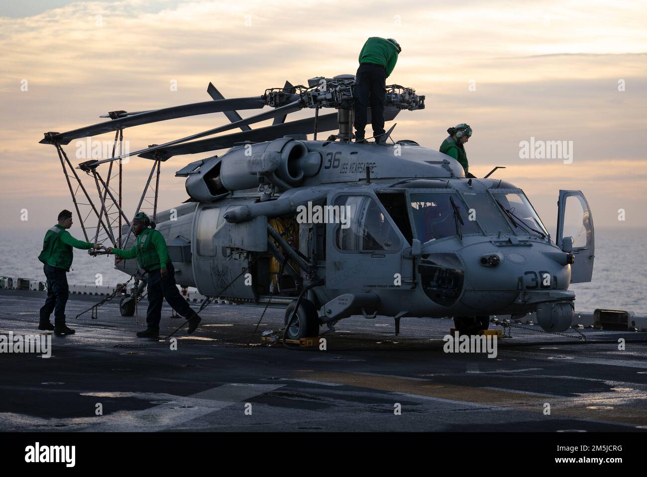 OCEANO ATLANTICO – i marinai eseguono le procedure pre-volo su un elicottero MH-60s Sea Hawk attaccato all'elicottero Sea Combat Squadron (HSC) 28, sul ponte di volo della nave d'assalto anfibia di classe Wasp USS Kearsarge (LHD 3) durante Fleet Battle Problem 22-1, 19 marzo 2022. FBP 22-1 integra capacità navali per supportare operazioni speciali, fornire difesa a terra e in mare, e sviluppare l'uso di veicoli subacquei senza equipaggio. Foto Stock