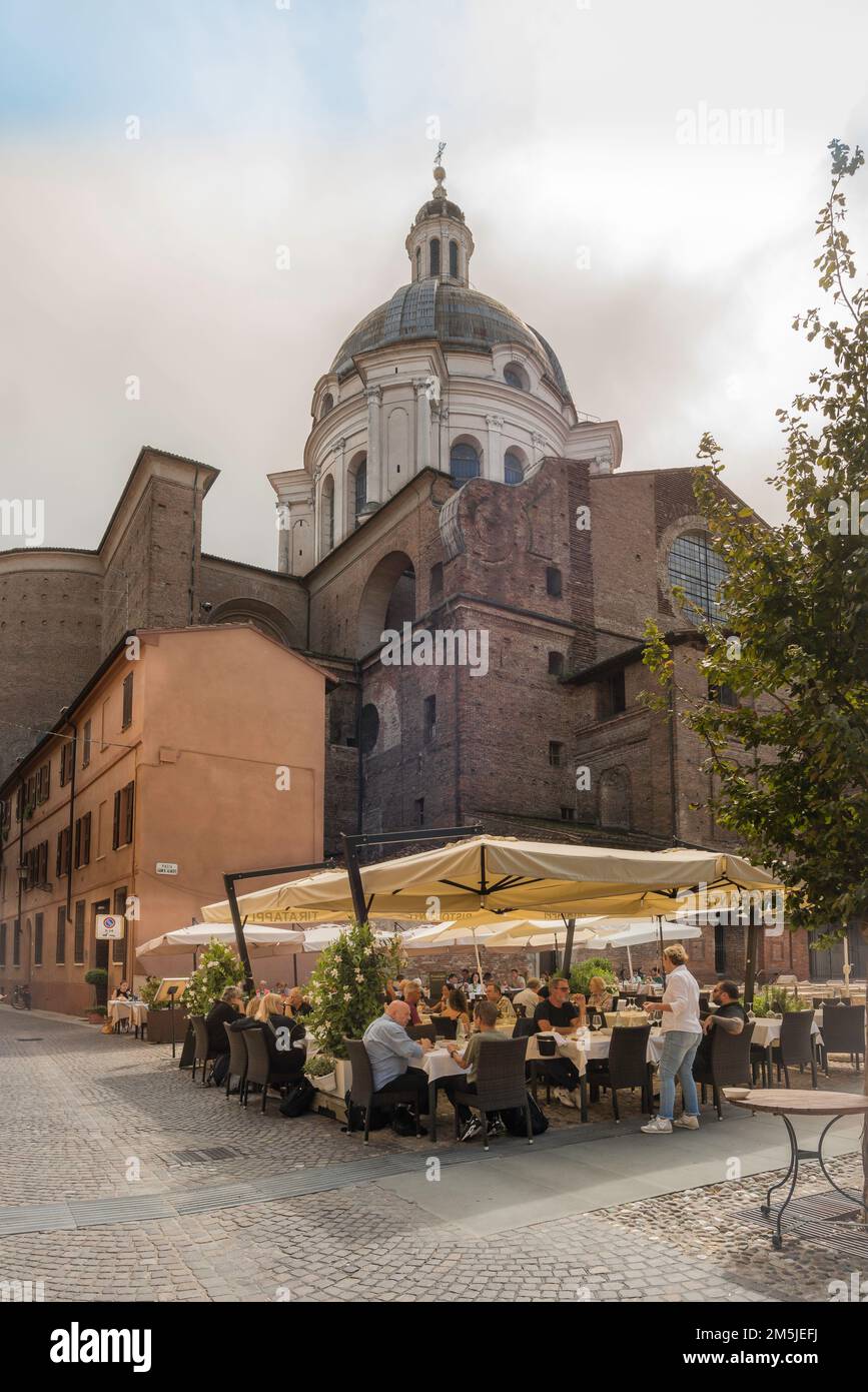 Piazza Mantova Italia, vista in estate delle persone che cenano sullo sfondo della chiesa di Sant'Andrea ai tavoli dei caffè in Piazza Leon Battista Alberti Foto Stock