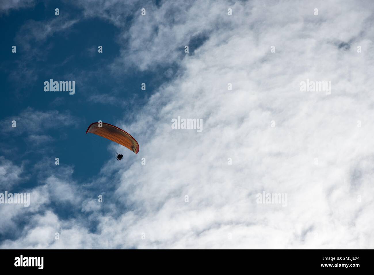 un appassionato di paraplano sulla spiaggia in volo Foto Stock