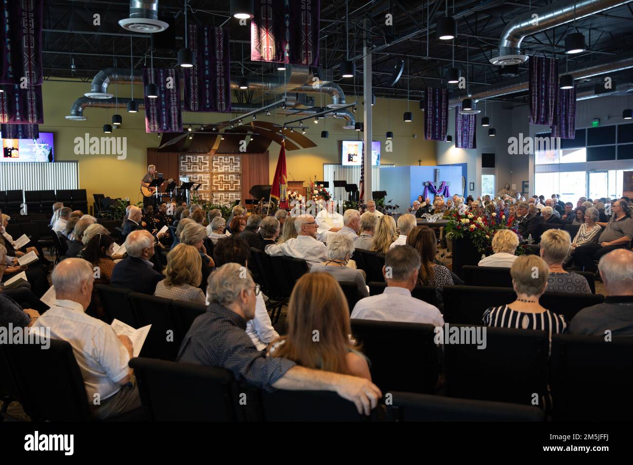 Amici e membri della famiglia abbracciano mentre onorano la vita del Lt. Col. David Althoff (in pensione), alla Chiesa di culto e lode Chandler Arizona, 19 marzo 2022. Althoff servì come pilota nella guerra del Vietnam e completò oltre 1.000 missioni di combattimento. Gli viene riconosciuto di aver salvato centinaia di marines che sono stati criticamente feriti in battaglia e che hanno ricevuto tre stelle d'argento, tre distinte croci volanti, una stella di bronzo, una medaglia di servizio meritoria e 55 medaglie d'aria. Foto Stock