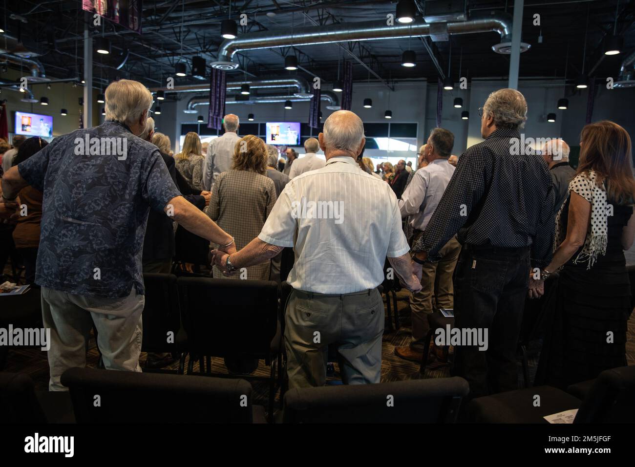 Amici e membri della famiglia abbracciano mentre onorano la vita del Lt. Col. David Althoff (in pensione), alla Chiesa di culto e lode Chandler Arizona, 19 marzo 2022. Althoff servì come pilota nella guerra del Vietnam e completò oltre 1.000 missioni di combattimento. Gli viene riconosciuto di aver salvato centinaia di marines che sono stati criticamente feriti in battaglia e che hanno ricevuto tre stelle d'argento, tre distinte croci volanti, una stella di bronzo, una medaglia di servizio meritoria e 55 medaglie d'aria. Foto Stock