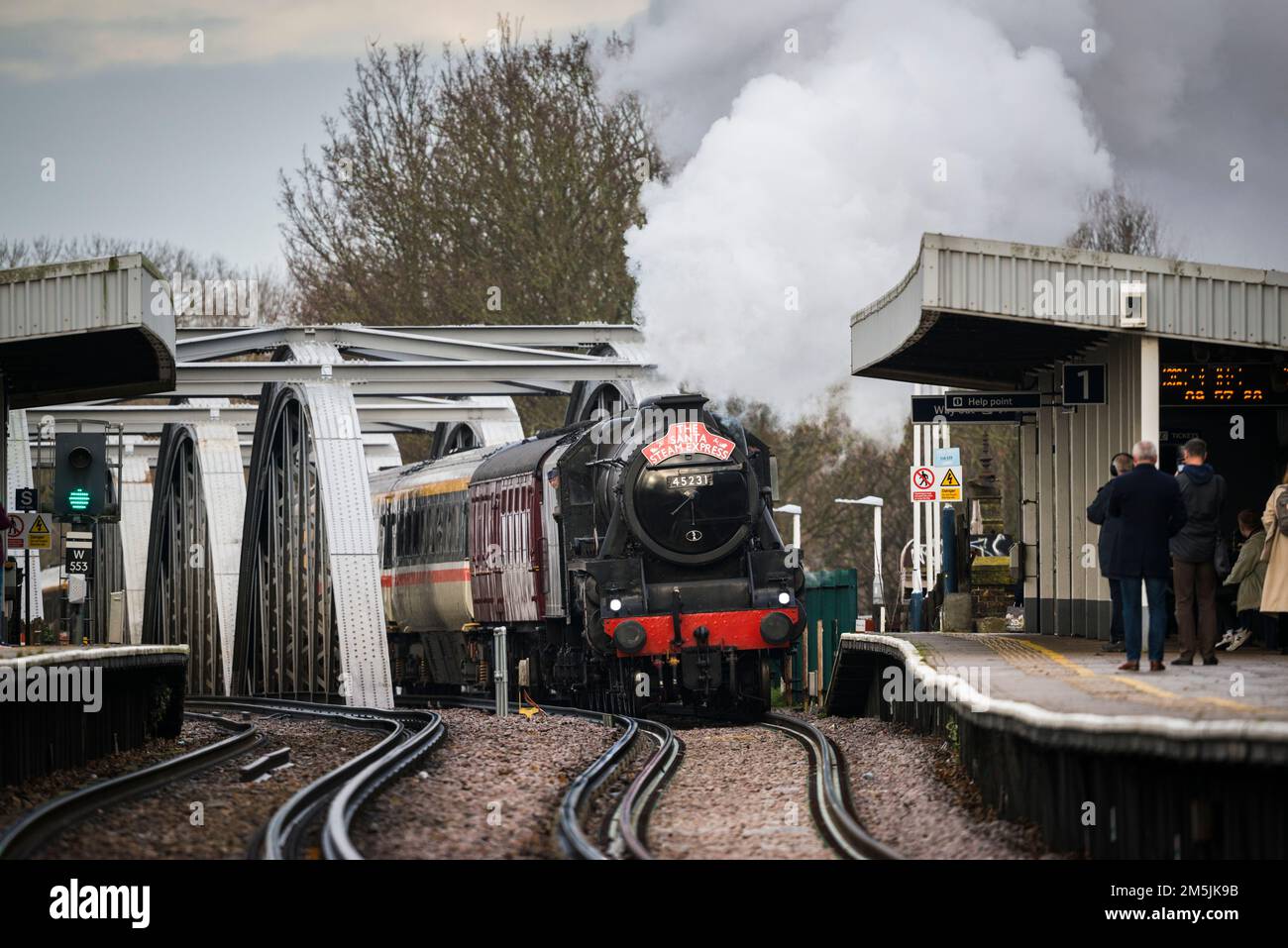 Treno a vapore 45231 The Sherwood Forester che arriva sul ponte ferroviario di Barnes e passando attraverso la stazione di Barnes Bridge, giorno di noia, speciale Natale Foto Stock