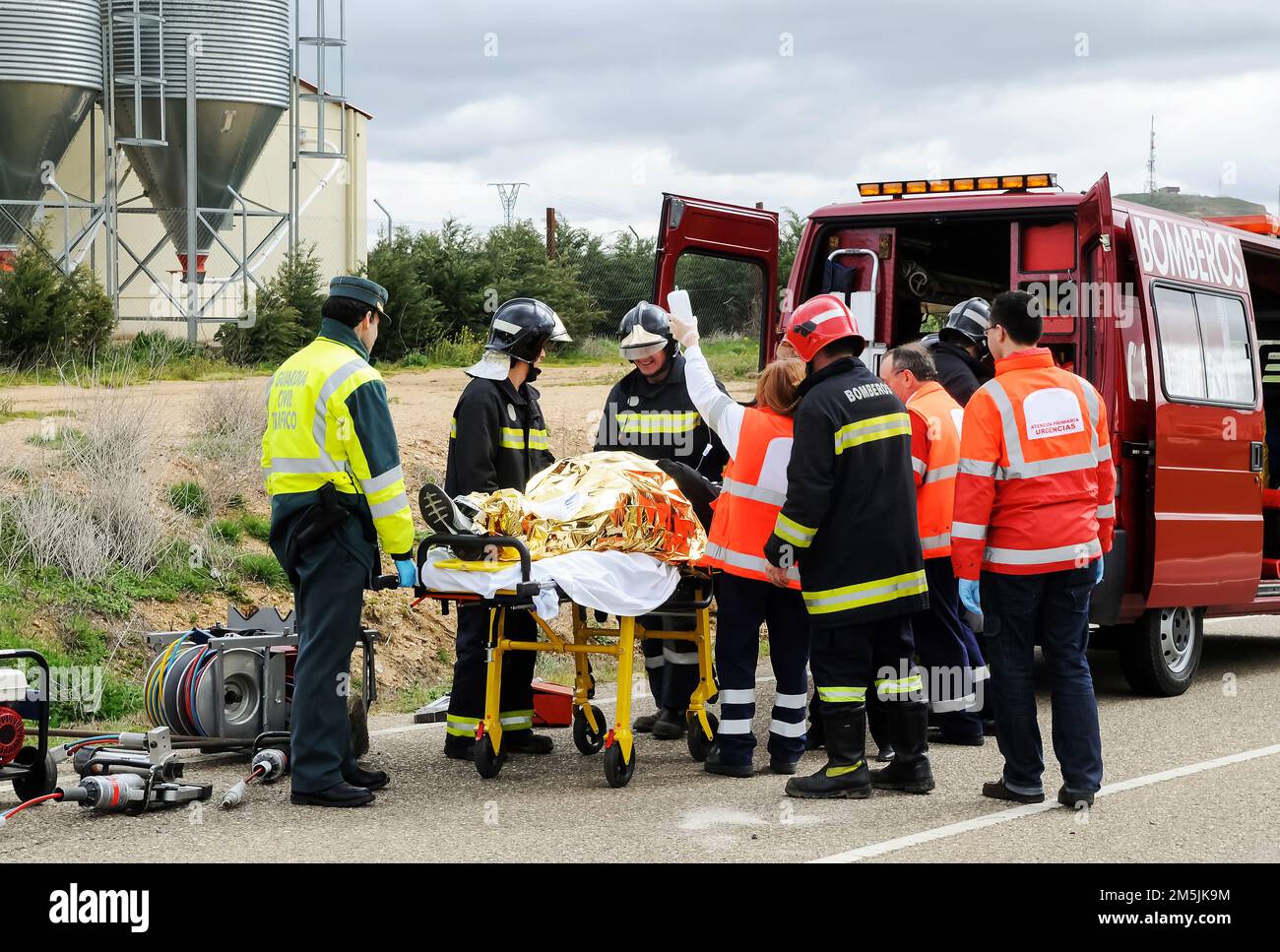 Vittime di un incidente stradale sono assistiti da servizi pubblici di emergenza con vigili del fuoco, paramedici e polizia. Foto Stock