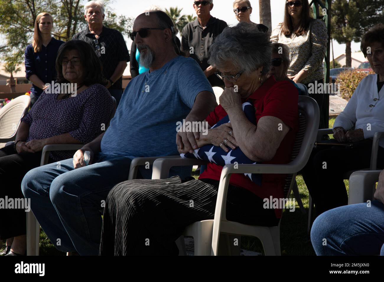 Karen Althoff accetta una bandiera americana in onore del suo defunto marito Lt. Col. David Althoff (in pensione), presso la Valle del Sole mortuario e cimitero, Chandler Arizona, 21 marzo 2022. Althoff servì come pilota nella guerra del Vietnam e completò oltre 1.000 missioni di combattimento. Gli viene riconosciuto di aver salvato centinaia di marines che sono stati criticamente feriti in battaglia e che hanno ricevuto tre stelle d'argento, tre distinte croci volanti, una stella di bronzo, una medaglia di servizio meritoria e 55 medaglie d'aria. Foto Stock