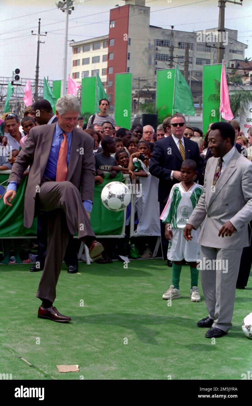Clinton Presidente (a sinistra) calci una palla di calcio davanti all'ex giocatore professionista di calcio Pele Edises (all'estrema destra) alla Mangueira School di Rio de Janeiro, Brasile, 10/15/1997. Foto di Ralph Alswang, Collezione Casa Bianca. Foto Stock
