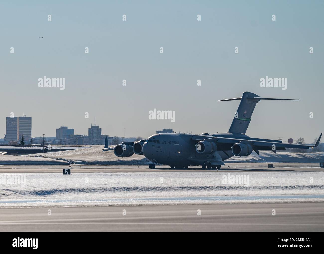 Un Globemaster III del C-17 assegnato alla base congiunta Lewis-McChord, Washington, atterra su una pista durante l'esercitazione Rainier War 22A alla base congiunta Elmendorf-Richardson, Alaska, 21 marzo 2022. L'esercizio è stato progettato per dimostrare la capacità dell'Ala 62nd Airlift di operare e sopravvivere sconfiggendo le sfide al vantaggio militare degli Stati Uniti in tutti i settori operativi: Aria, terra, mare e cyberspazio. Foto Stock