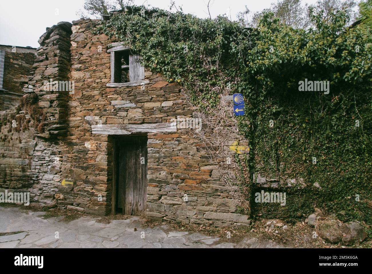 Un vecchio casale derelitto con un marcatore per i pellegrini sulla via San Giacomo a Santiago de Compostela Foto Stock