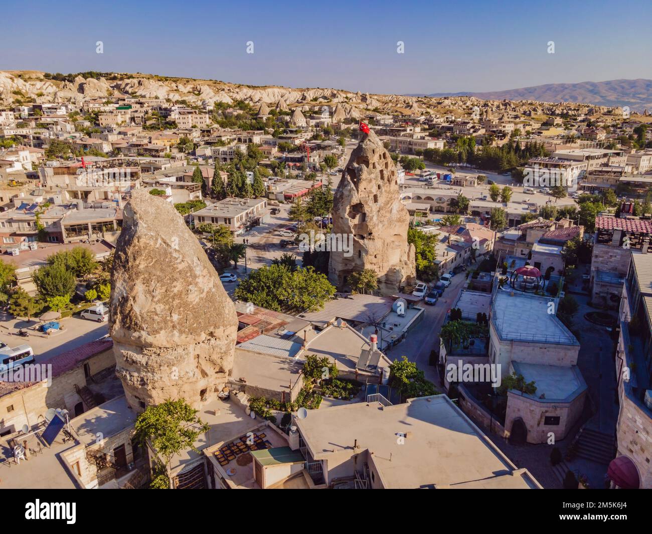 Bandiera turca sulla collina con tipiche formazioni rocciose di tufo della Cappadocia sullo sfondo di un cielo blu, Goreme, Turchia Foto Stock