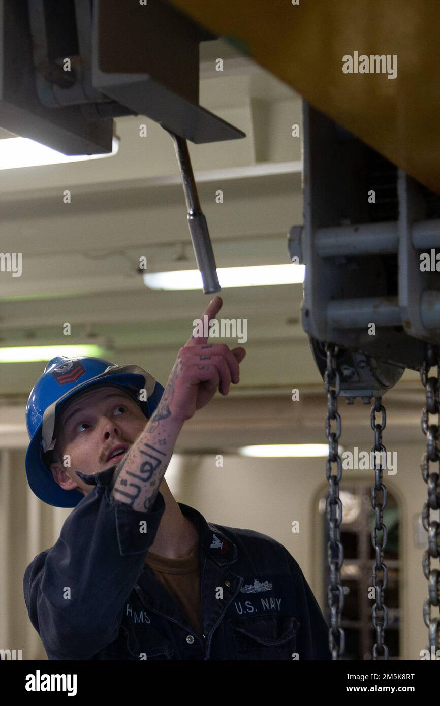 Boatswain's Mate 2nd Class Houston Helms, di Cedar Bluff, Alabama, assegnato al reparto coperta della USS Gerald R. Ford (CVN 78), ispeziona il portale di ancoraggio in Ford’s fo’sle, 21 marzo 2022. Ford è in corso nell’Oceano Atlantico per la certificazione del ponte di volo e le qualifiche del vettore aereo come parte della fase di base su misura della nave prima dello spiegamento operativo. Foto Stock