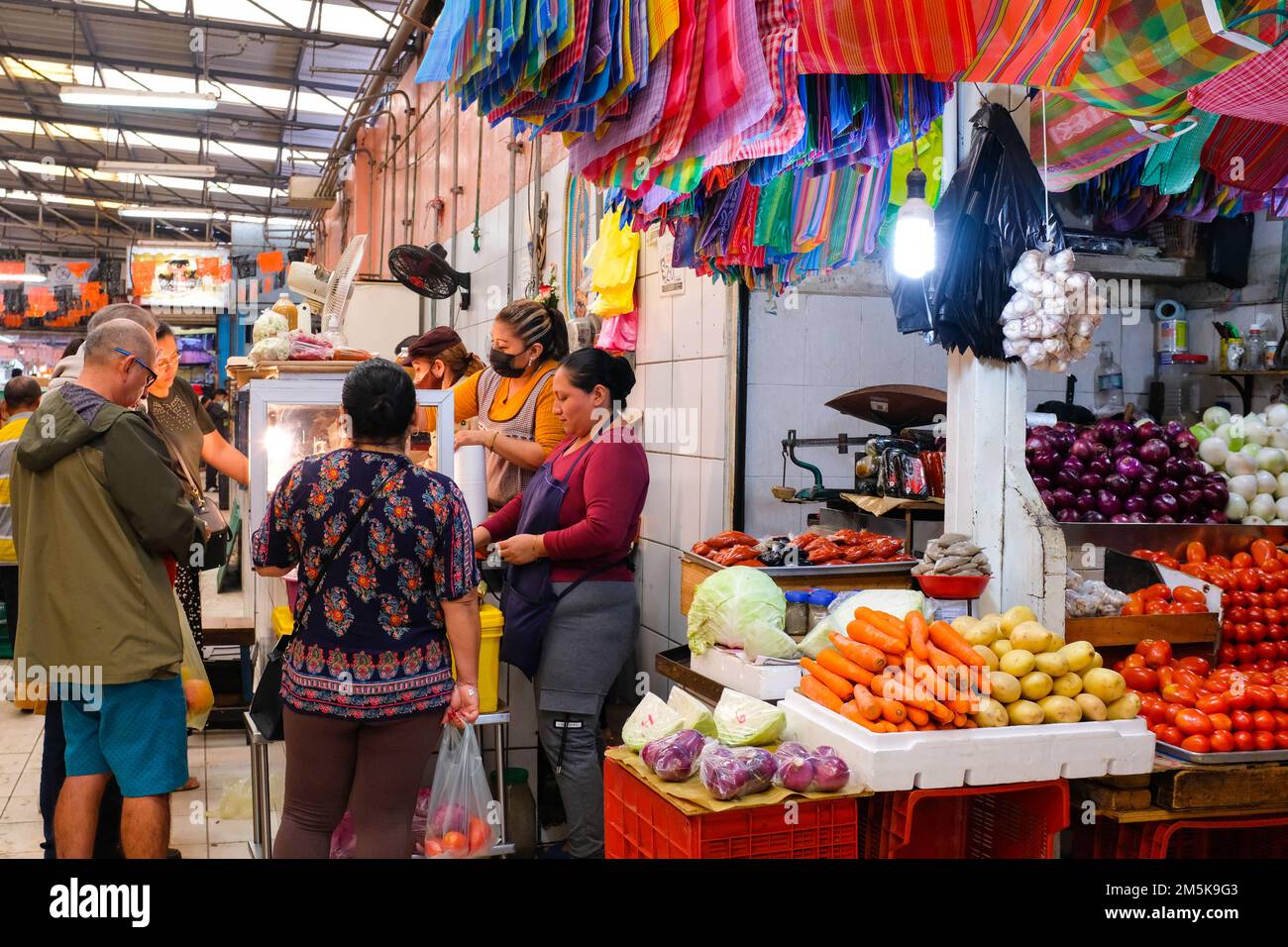 La gente si allinea ad una stalla che vende le carni preparate al mercato di Lucas de Galvez nel centro di Merida, Yucatan, Messico Foto Stock