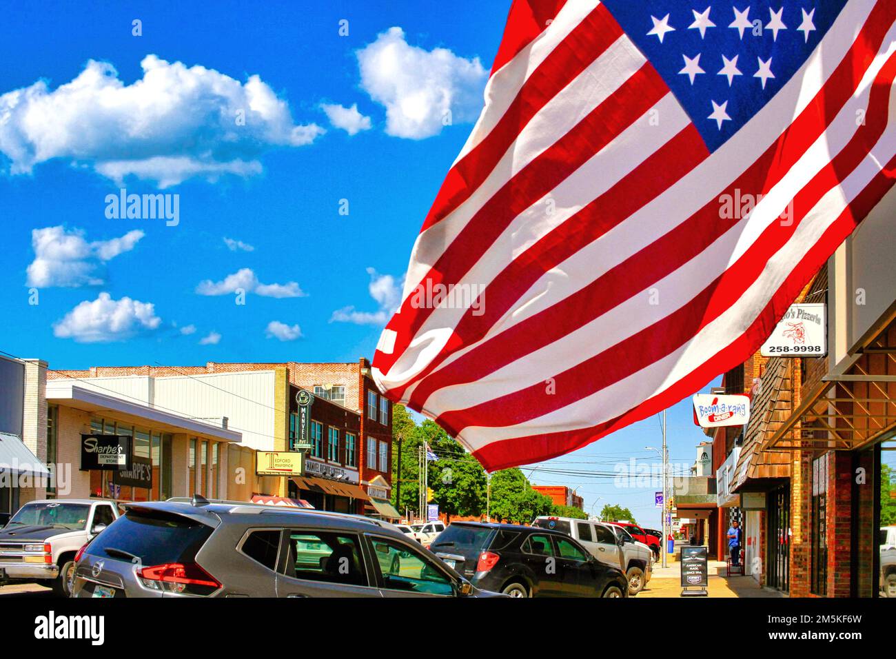 Una bandiera americana risalta nella brezza su Manvel Avenue nel centro di Chandler, Oklahoma. Foto Stock