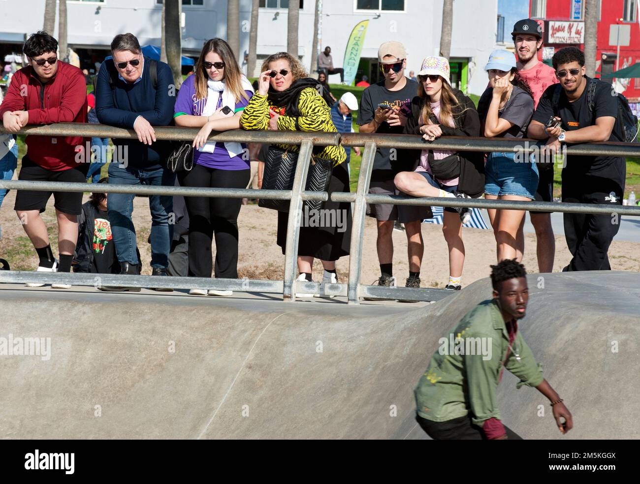 I turisti che guardano gli skateboard al Venice Beach skate Park vicino al lungomare in California, USA. Foto Stock