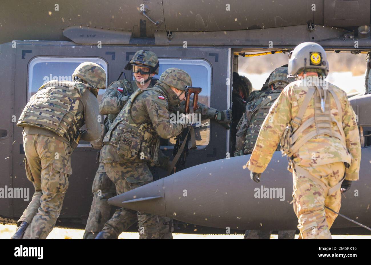 STATI UNITI I paracadutisti dell'esercito assegnati a 1st Brigade Combat Team, 82nd Airborne Division addestrano i militari polacchi sulle procedure di caricamento a caldo su un US Elicottero Army Black Hawk a Bircza, Polonia, marzo 22. La 82nd Airborne Division, con sede a Fort Bragg, N.C., è stata dispiegata in Polonia come parte del forte e indefesso impegno nei confronti dei nostri alleati della NATO. Foto Stock
