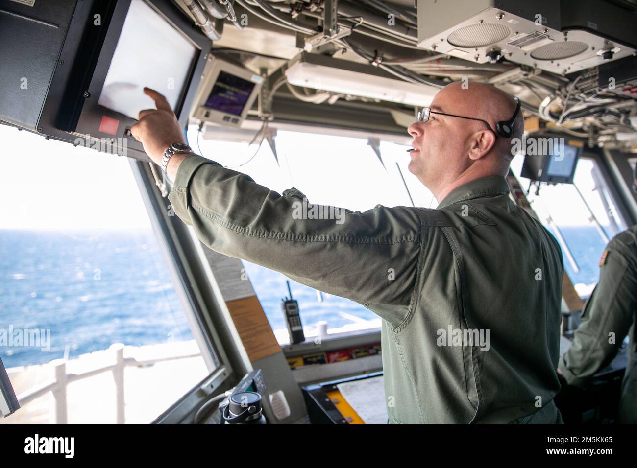 CMdR. John Ciganovich, USS Gerald R. Ford’s (CVN 78) Air boss, analizza una lettura computerizzata nel controllo primario del volo, 22 marzo 2022. Ford è in corso nell’Oceano Atlantico per la certificazione del ponte di volo e la qualifica del vettore aereo come parte della fase di base su misura della nave prima dello spiegamento operativo. Foto Stock