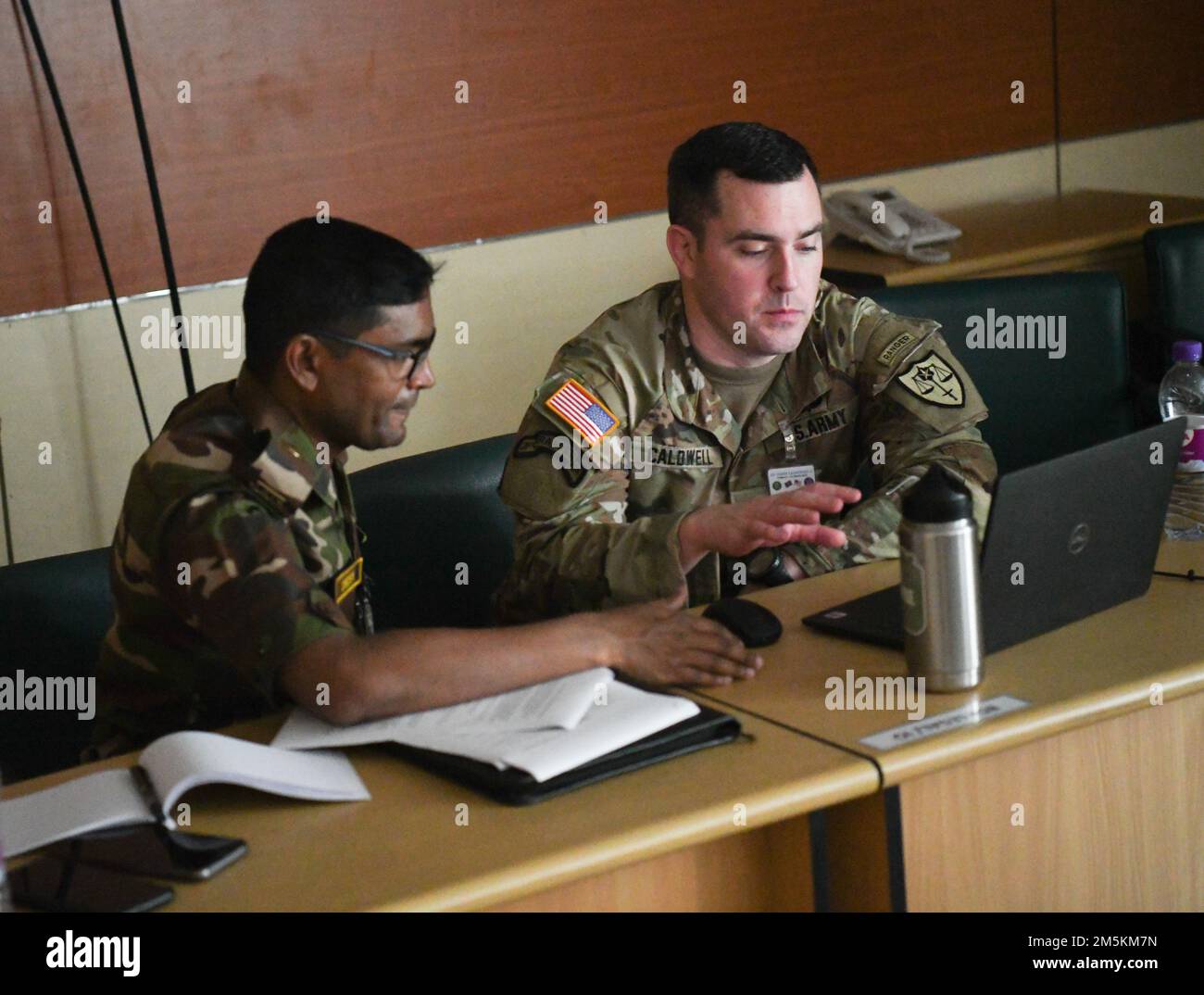 STATI UNITI Trevor Caldwell, delegato della Guardia Nazionale dell'Oregon e ufficiale dell'Avvocato Generale del Giudice (JAG), parla con il suo omologo del Bangladesh su questioni giuridiche mentre si trova al centro di formazione dell'operazione di sostegno alla Pace dell'Istituto del Bangladesh (BIPSOT) a Dhaka, Bangladesh, il 23 marzo 2022. I delegati della Guardia Nazionale dell'Oregon partecipano all'esercitazione Tiger Lightning 2022, un'esercitazione bilaterale sponsorizzata dagli Stati Uniti Comando Indo-Pacific e ospitato dalle forze Armate del Bangladesh, rafforzando la preparazione alla difesa del Bangladesh, creando interoperabilità operativa e rafforzando la partnership tra loro Foto Stock