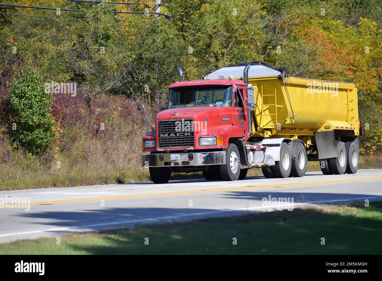 Streamwood, Illinois, Stati Uniti. Un autocarro che passa attraverso un'area boscosa durante una corsa autunnale. Foto Stock