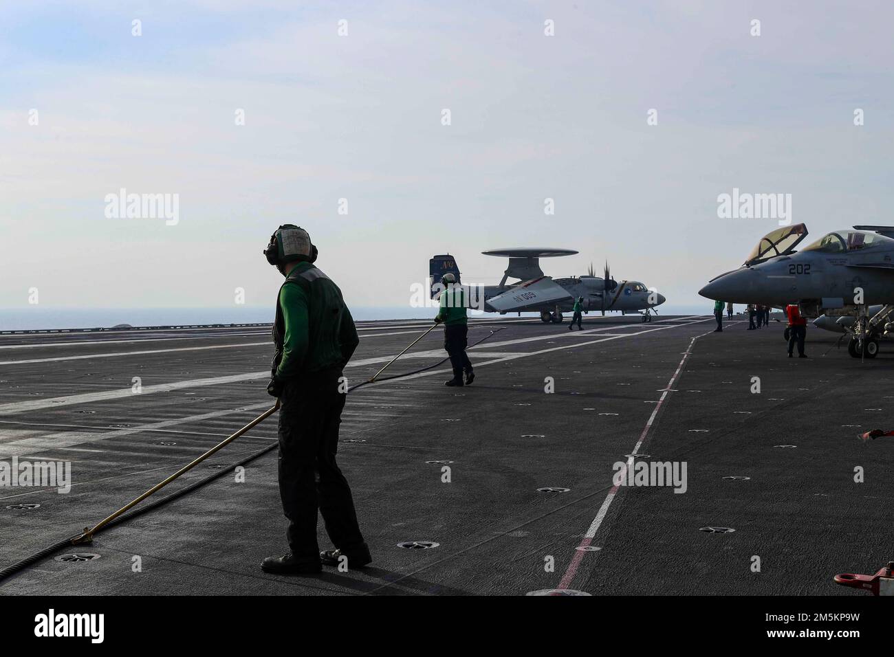 SOUTH CHINA SEA (23 marzo 2022) Airman Luke Hernandez, partito, da Screwston, Texas, e Airman Christian Hatfield, da Lexington, Ky., si preparano a spingere indietro un filo di arresto sul ponte di volo della portaerei di classe Nimitz USS Abraham Lincoln (CVN 72). Abraham Lincoln Strike Group è in fase di implementazione pianificata nell'area delle operazioni della flotta 7th degli Stati Uniti per migliorare l'interoperabilità attraverso alleanze e partnership e al tempo stesso fungere da forza di risposta pronta a sostegno di una regione indomPacifico libera e aperta. Foto Stock