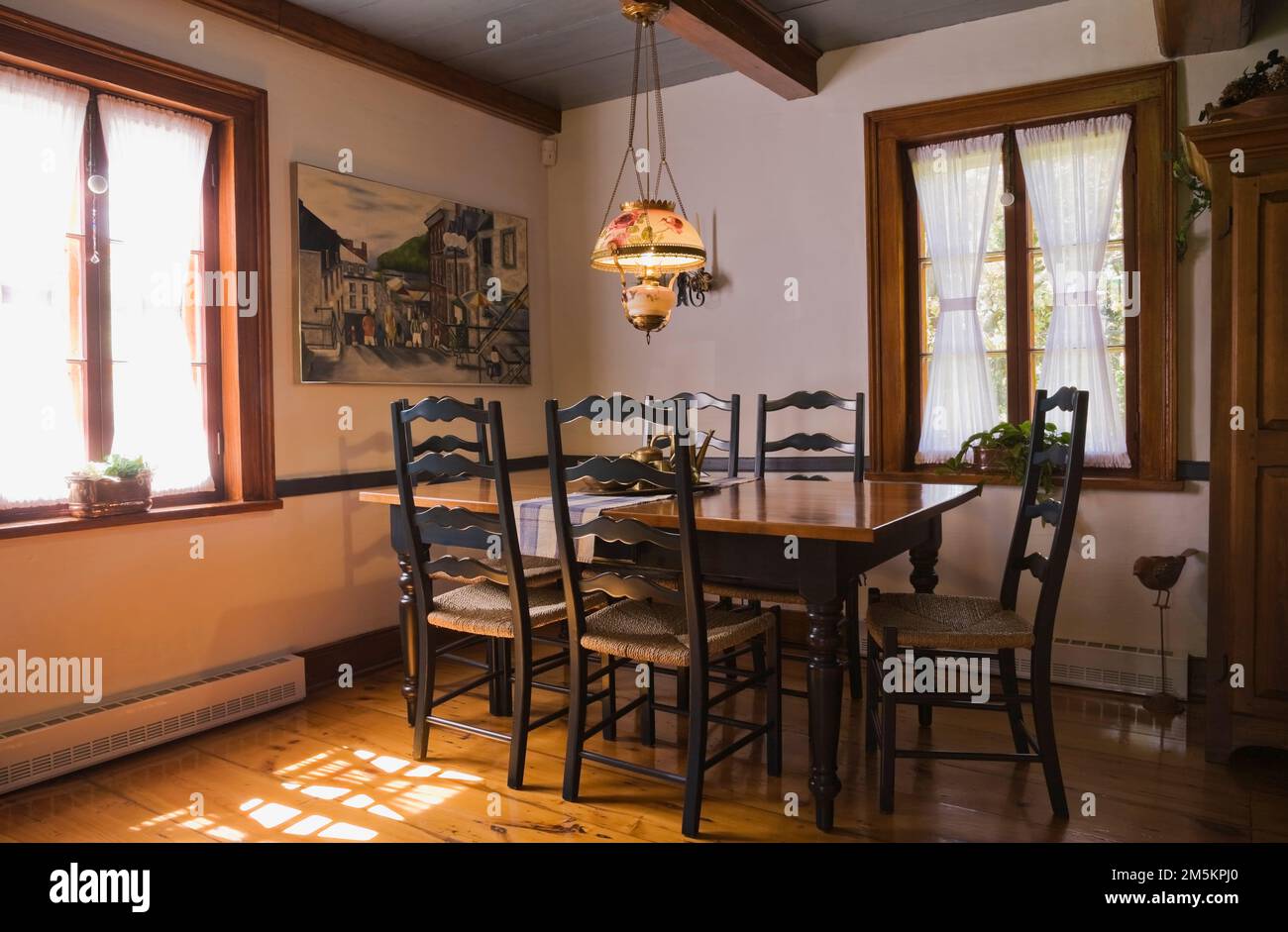 Antico tavolo da pranzo in legno con sedie con schienale alto intrecciato nella sala da pranzo all'interno di una casa in legno ricostruita degli anni '1840. Foto Stock