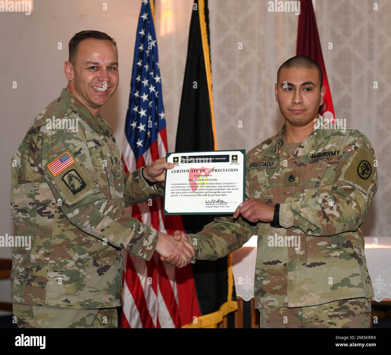 STATI UNITI Il comando dell'esercito Sgt. Maji. Kyle Brunell, il comando regionale della sanità Europa presenta il personale Sgt. Alejandro Preciado, tecnico di cura degli animali al Centro medico veterinario Europa, Un certificato di apprezzamento da parte del governo americano dell'esercito per aver rappresentato il comando regionale della salute Europa al recente comando Sgt. Major Jack M. Clark Best Medic Competition a Fort Hood Texas durante il comando della sanità pubblica Europa, cerimonia di rinuncia della responsabilità, 23 marzo 2022 a Landstuhl, Germania. Foto Stock