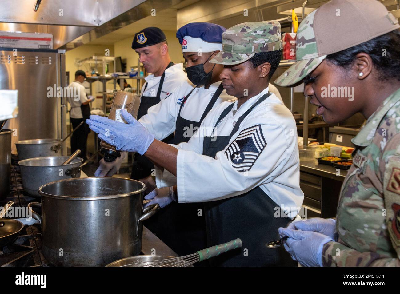 STATI UNITI I militari partecipano a un concorso a pezzi alla base dell'aeronautica militare Travis, California, 23 marzo 2022. Il 60th Mission Support Group Monarch Dining Facility ha ospitato un concorso di cucina che mostra abilità, velocità e ingegnosità. Squadre di quattro persone si sono esibite per trasformare gli ingredienti misteriosi in piatti di portata principale e dessert da presentare a un gruppo di giudici. Foto Stock