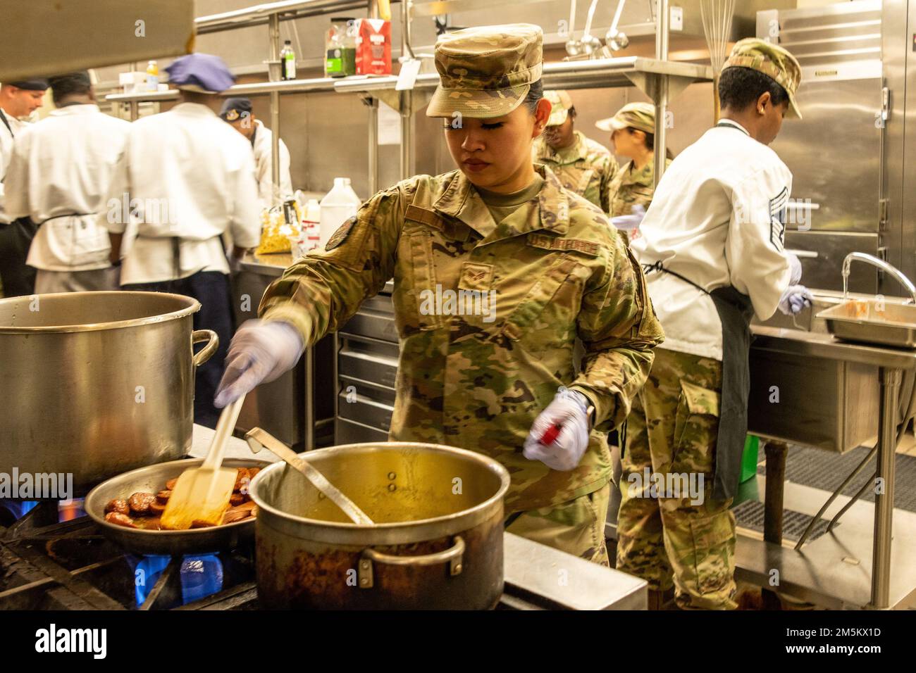 STATI UNITI Air Force Airman 1st Class Cynthia li, 60th Force Support Squadron food service journeyman, patina la salsiccia durante una gara tritata alla base dell'aeronautica militare Travis, California, 23 marzo 2022. Il 60th Mission Support Group Monarch Dining Facility ha ospitato un concorso di cucina che mostra abilità, velocità e ingegnosità. Squadre di quattro persone si sono esibite per trasformare gli ingredienti misteriosi in piatti di portata principale e dessert da presentare a un gruppo di giudici. Foto Stock