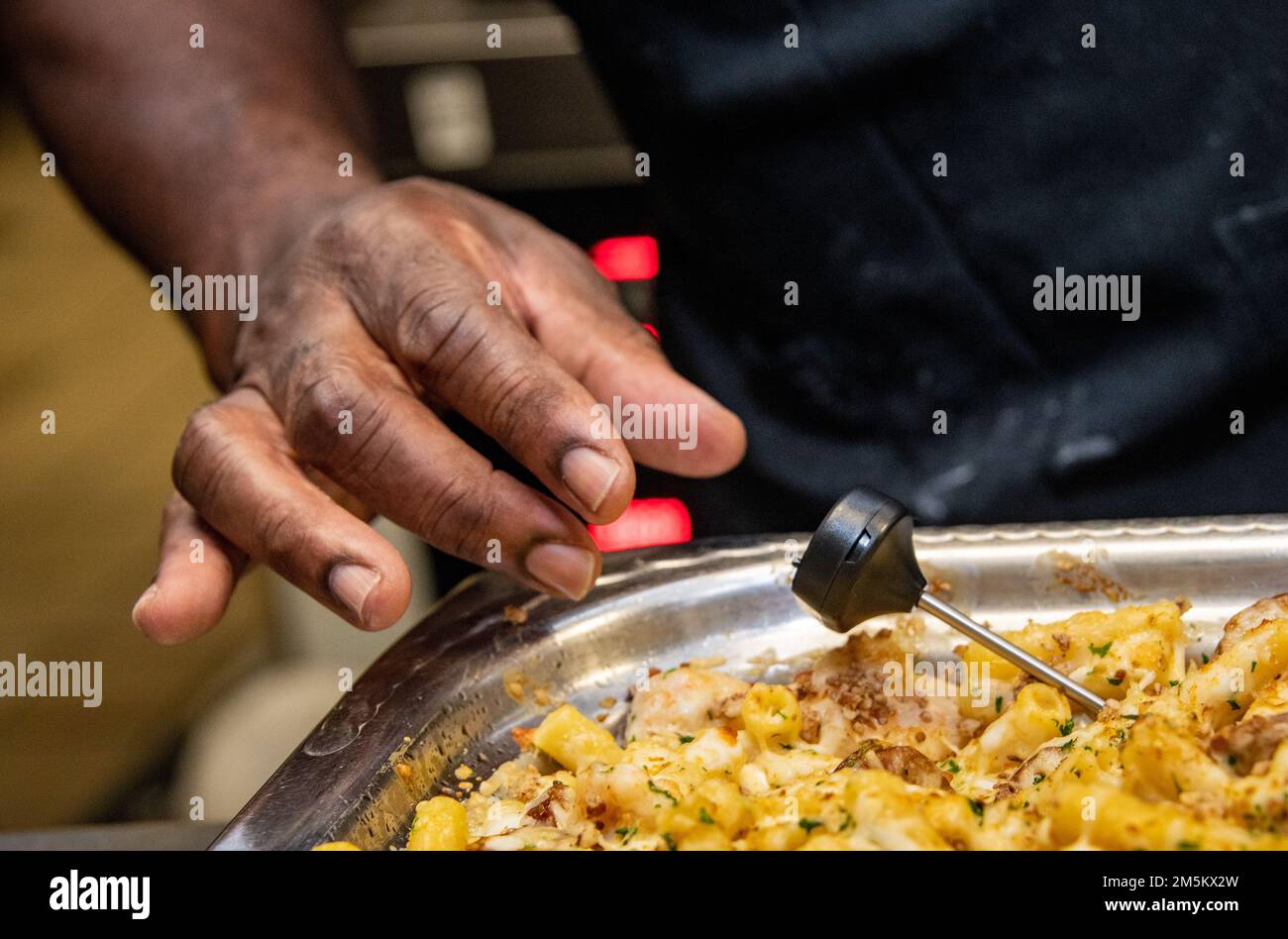 Reginald Barkus, 60th Force Support Squadron Food Service Cook, assicura che il cibo venga mantenuto a una temperatura sicura prima di essere servito alla Travis Air Force base, California, 23 marzo 2022. Il 60th Mission Support Group Monarch Dining Facility ha ospitato un concorso di cucina che mostra abilità, velocità e ingegnosità. Squadre di quattro persone si sono esibite per trasformare gli ingredienti misteriosi in piatti di portata principale e dessert da presentare a un gruppo di giudici. Foto Stock