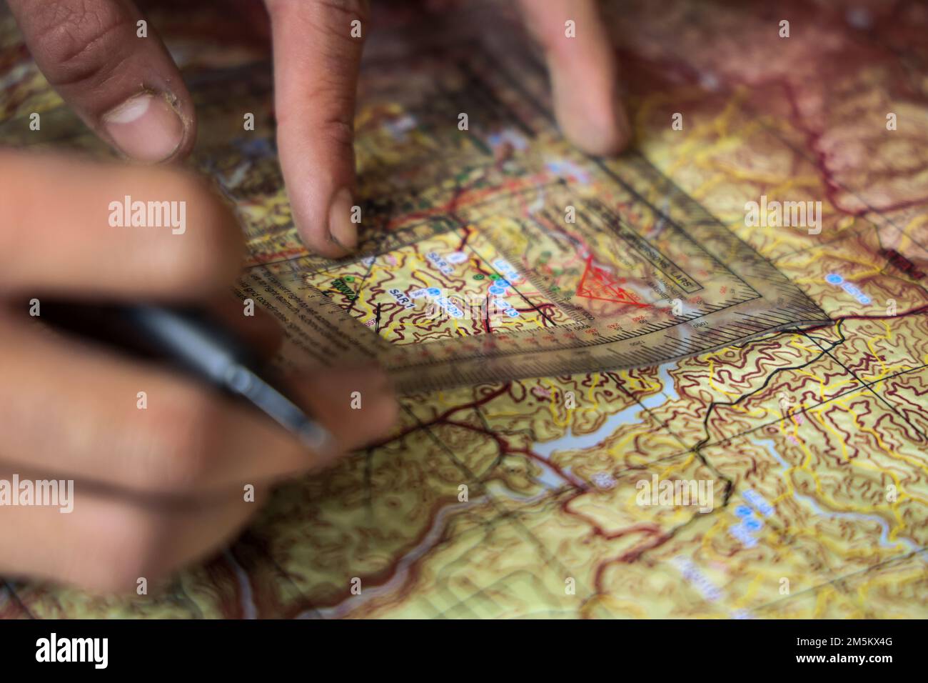 STATI UNITI Marines con 3D Intelligence Battalion, III Marine Expeditionary Force Information Group, traccia determinate posizioni e calcola il percorso su una mappa prima dell'addestramento alla navigazione terrestre presso il Jungle Warfare Training Center, Camp Gonsalves, Okinawa, Giappone, marzo 23, 2022. La navigazione terrestre è stata condotta nell'ambito di un esercizio generale di Jungle Field condotto dal 21 al 25 marzo. Durante il FEX, III MIG Marines ha praticato la loro capacità di condurre operazioni distribuite in un ambiente austero. JWTC fornisce terreno impegnativo che si trova su molte delle isole dell'Indo-Pacifico. Padronanza di Foto Stock