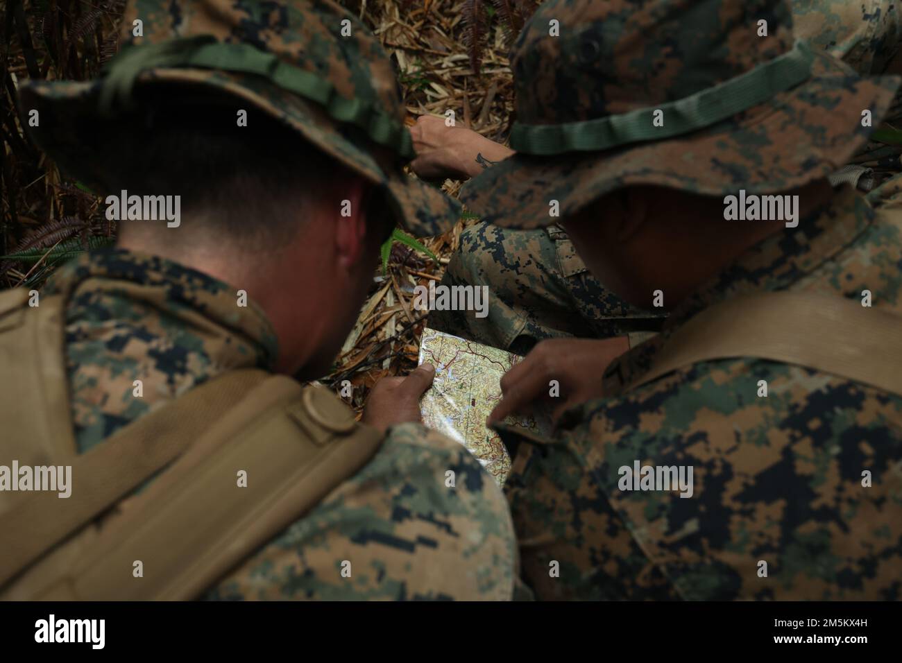 STATI UNITI Marines con 3D Intelligence Battalion, III Marine Expeditionary Force Information Group, controlla la loro posizione su una mappa durante un corso di navigazione terrestre presso il Jungle Warfare Training Center, Camp Gonsalves, Okinawa, Giappone, marzo 23, 2022. La navigazione terrestre è stata condotta nell'ambito di un esercizio generale di Jungle Field condotto dal 21 al 25 marzo. Durante il FEX, III MIG Marines ha praticato la loro capacità di condurre operazioni distribuite in un ambiente austero. JWTC fornisce terreno impegnativo che si trova su molte delle isole dell'Indo-Pacifico. La padronanza di questo terreno contribuisce a. Foto Stock