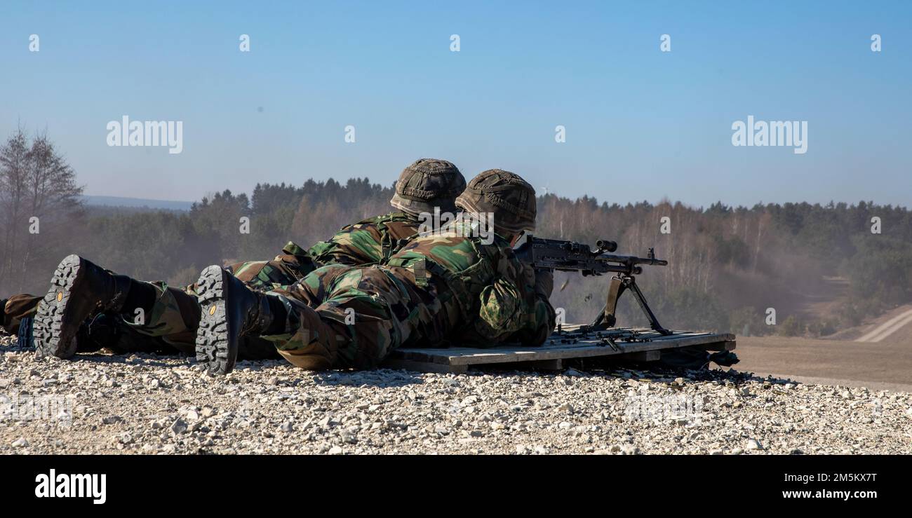 A Marine ricarica il 7,62 FN MAG per il suo collega arruolato alla Grafenwoehr Training Area, 23 marzo 2022. Sul campo, i Marines lavorano in coppia per utilizzare l'arma con la massima efficienza. Foto Stock