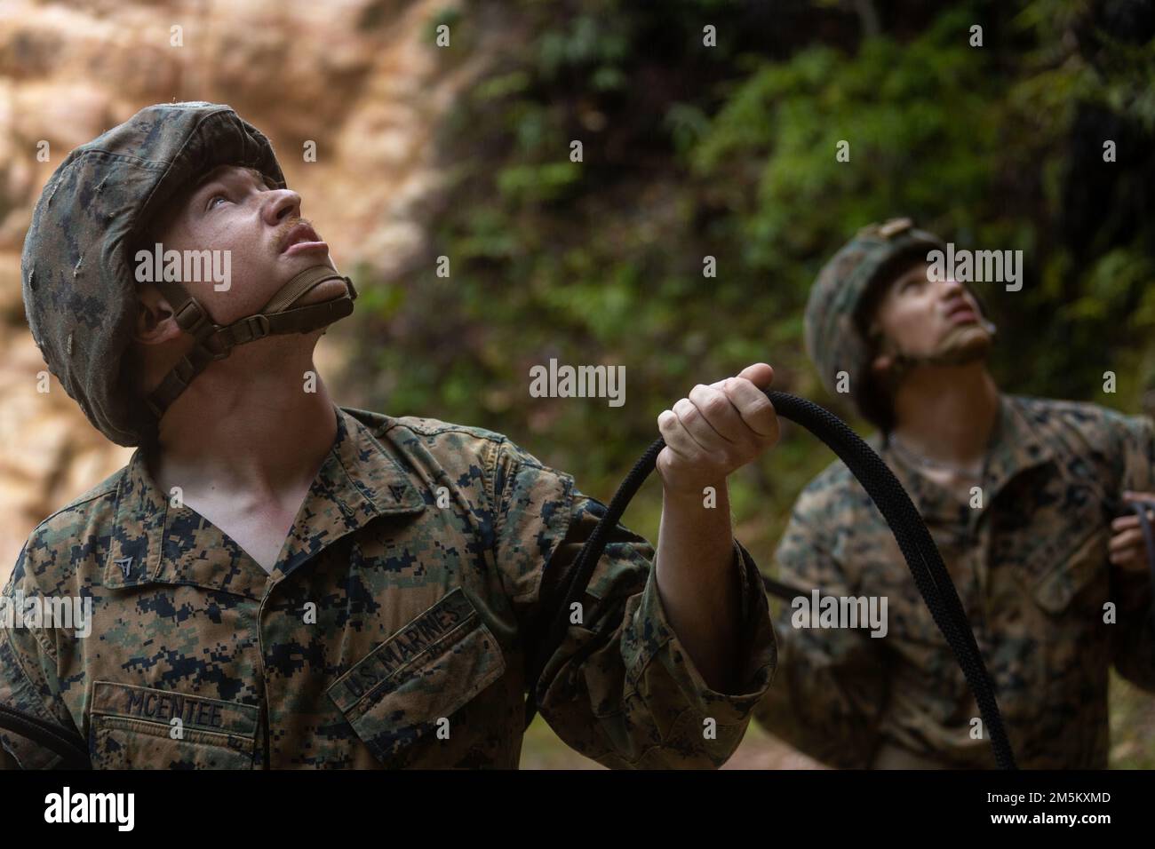 STATI UNITI Marine Corps Lance CPL. MCentee with III Marine Expeditionary Force Information Group belays for Marines Rappelling during Jungle Rappelling Training Center at Jungle Warfare Training Center, Camp Gonsalves, Okinawa, Japan, March 23, 2022. L'addestramento di rappelling faceva parte di un'esercitazione generale sul campo della giungla condotta il 21-25 marzo. Durante il FEX, III MIG Marines ha praticato la loro capacità di condurre operazioni distribuite in un ambiente austero. JWTC fornisce terreno impegnativo che si trova su molte delle isole dell'Indo-Pacifico. La padronanza di questo terreno contribuisce alla capacità di III MIG Foto Stock