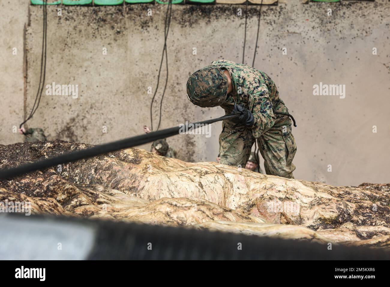 NEGLI STATI UNITI Marine with III Marine Expeditionary Force Information Group si impiglia su una scogliera durante l'addestramento dei rappel nella giungla al Jungle Warfare Training Center, Camp Gonsalves, Okinawa, Giappone, marzo 23, 2022. L'addestramento di rappelling faceva parte di un'esercitazione generale sul campo della giungla condotta il 21-25 marzo. Durante il FEX, III MIG Marines ha praticato la loro capacità di condurre operazioni distribuite in un ambiente austero. JWTC fornisce terreno impegnativo che si trova su molte delle isole dell'Indo-Pacifico. La padronanza di questo terreno contribuisce alla capacità di III MIG di impiegare più modalità di bassa signa Foto Stock