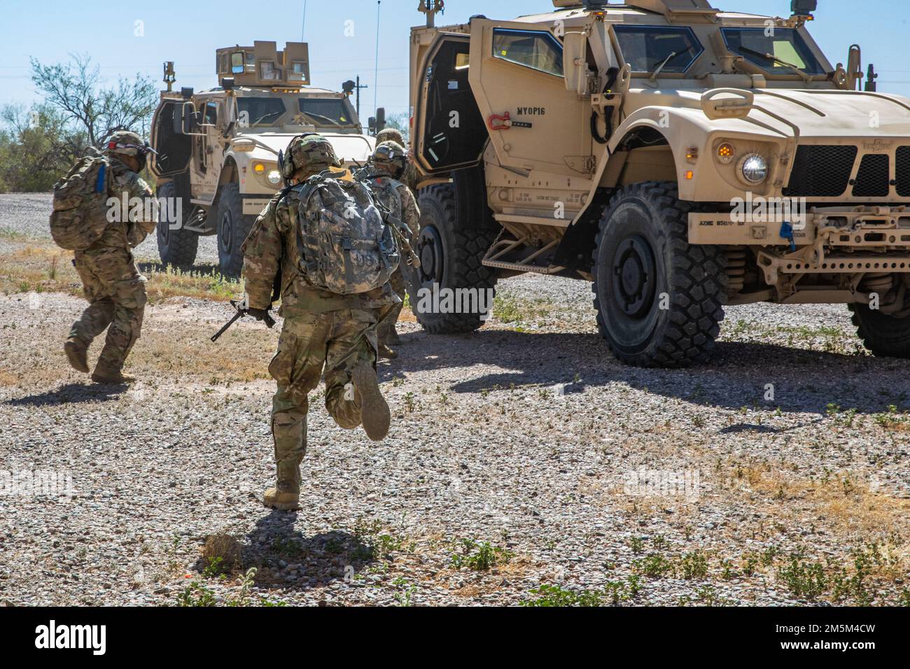 Tre concorrenti di Best Warrior corrono sotto un fuoco simulato per entrare in due veicoli all-Terrain protetti da imboscata (M-ATV) in attesa di resistenza alle mine durante l'evento militare su terreno urbanizzato (MOUT) presso la Riserva militare di Firenze, a Firenze, Ariz., 24 marzo 2022. Il concorso AZNG Best Warrior Competition è un evento specializzato che si concentra sulla fornitura di una serie di valutazioni delle abilità dei soldati che testano e addestrano i cittadini-soldati che provengono dalle nostre diverse comunità Foto Stock