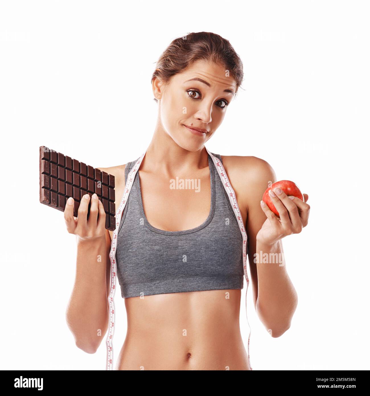 Il suo corpo, fare la scelta giusta. Studio shot di una giovane donna attraente che decide tra cibi sani e non sani. Foto Stock Il suo corpo, fare la scelta giusta. Studio shot di una giovane donna attraente che decide tra cibi sani e non sani. Foto Stock