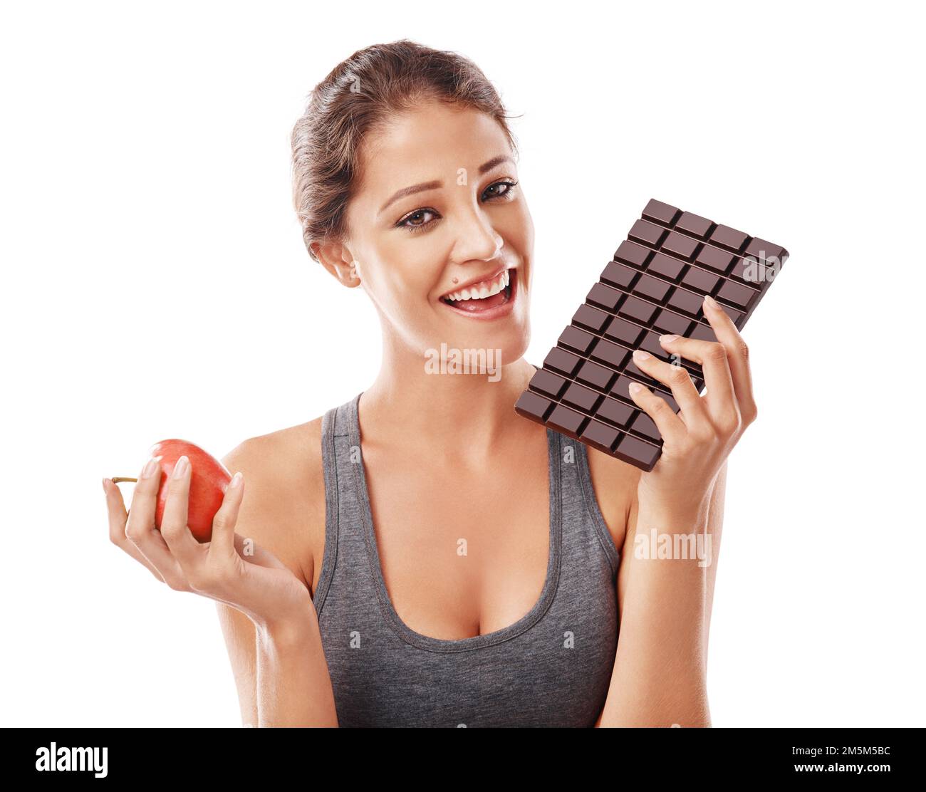 Credo che il cioccolato faccia parte di una dieta sana. Studio shot di una giovane donna attraente che decide tra cibi sani e non sani. Foto Stock Credo che il cioccolato faccia parte di una dieta sana. Studio shot di una giovane donna attraente che decide tra cibi sani e non sani. Foto Stock