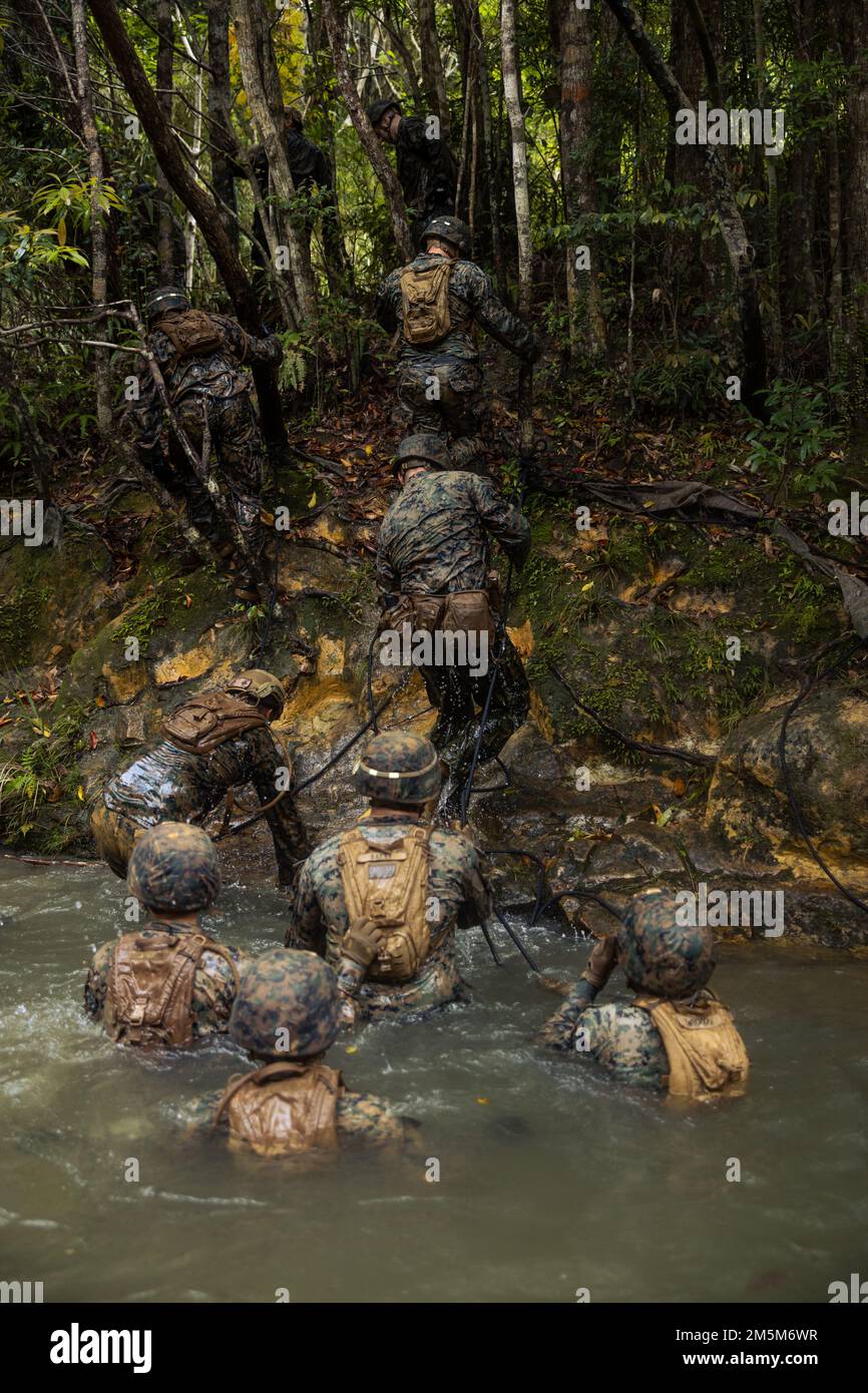 STATI UNITI Marines con III Marine Expeditionary Force Information Group si arrampicano da un ostacolo d'acqua durante un corso di resistenza al Jungle Warfare Training Center, Camp Gonsalves, Okinawa, Giappone, 24 marzo 2022. Il corso di resistenza è stato condotto come parte di un esercizio generale di Jungle Field condotto il 21-25 marzo. Durante il FEX, III MIG Marines ha praticato la loro capacità di condurre operazioni distribuite in un ambiente austero. JWTC fornisce terreno impegnativo che si trova su molte delle isole dell'Indo-Pacifico. La padronanza di questo terreno contribuisce alla capacità di III MIG di impiegare mod multipli Foto Stock