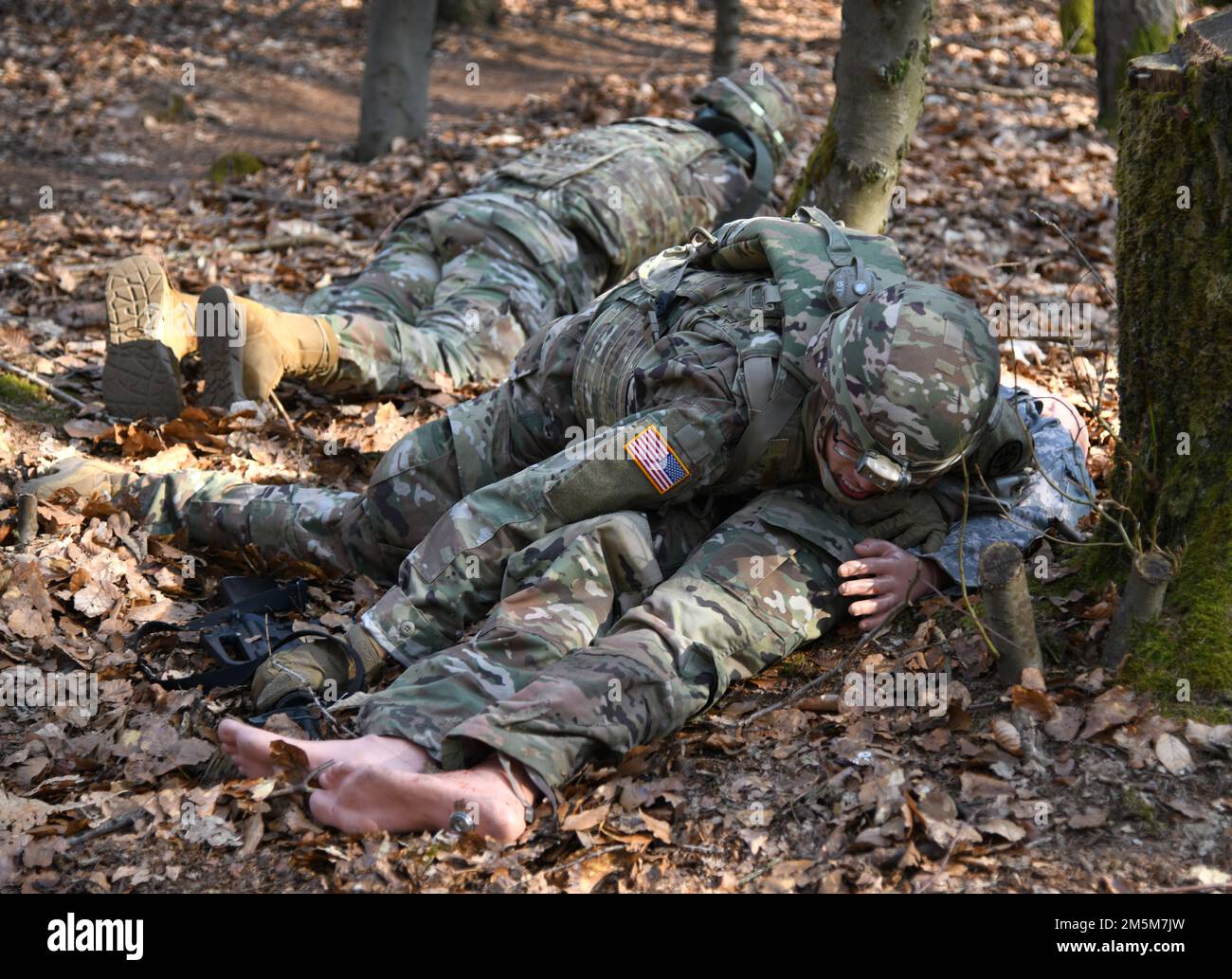 STATI UNITI Esercito CPT. Bradley Trolley assegnato a DENTAC Rheinland-Pfalz protegge un incidente mentre è sotto un incendio simulato durante il concorso migliore guerriero in Europa 2022 del Dental Health Command presso la Landstuhl Training Area, 24 marzo 2022. Il concorso di 5 giorni durò dal 21-25 marzo e consisteva in navigazione terrestre diurna e notturna, test di idoneità al combattimento dell'esercito, qualificazione da stress M4 e M17, una marcia stradale di 12 miglia, corso di ostacolo, corsia di assistenza agli incidenti prolungata, corsia di competenza MOS/AOC, un esame scritto e una lavagna orale. Foto Stock