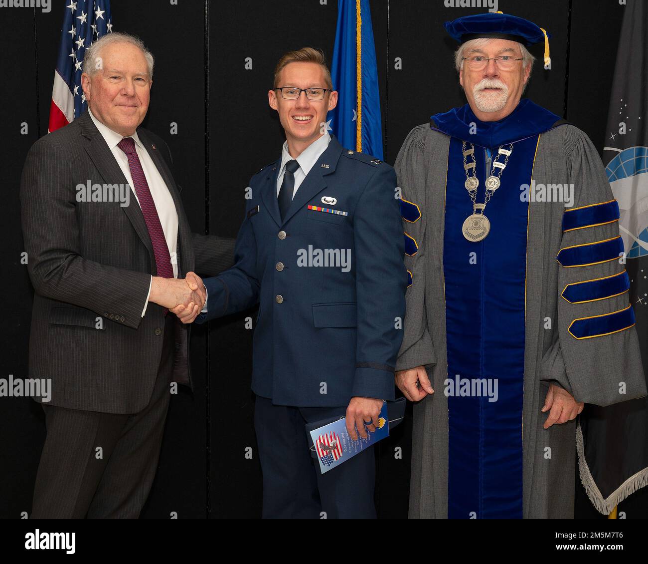 Il Segretario dell'aeronautica Frank Kendall presenta una moneta a un laureato di primo livello prima della cerimonia di laurea dell'Air Force Institute of Technology presso il Museo Nazionale degli Stati Uniti Air Force presso la base dell'aeronautica militare Wright-Patterson, Ohio, 24 marzo 2022. Il dottor Walter Jones, direttore e cancelliere dell'AFIT, si è Unito a Kendall nel riconoscere gli illustri laureati. Foto Stock