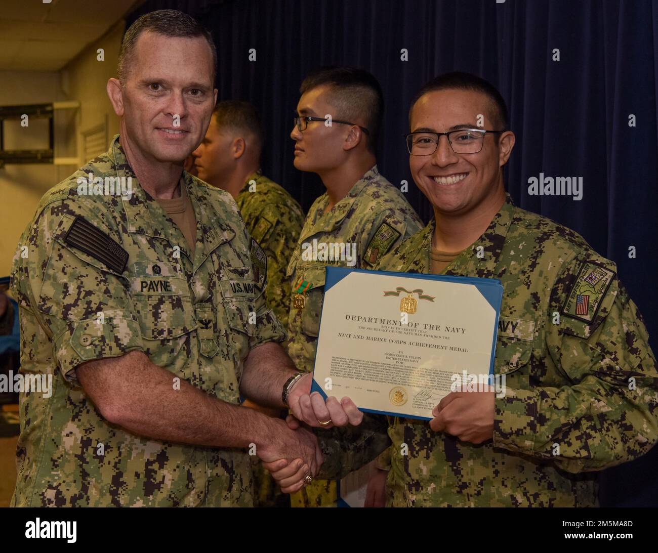 220325-N-EJ241-1008 DIEGO GARCIA, British Indian Ocean Territory (25 marzo 2022) – Ensign Cody R. Fulton, Food Service Officer for Naval Support Facility (NSF) Diego Garcia, riceve una Medaglia ai risultati del corpo della Marina e della Marina dal Capt. Richard D. Payne, ufficiale comandante di NSF Diego Garcia durante i premi ai quarti. NSF Diego Garcia fornisce supporto logistico, di servizio, ricreativo e amministrativo agli Stati Uniti e alle forze alleate schierate in avanti nell'Oceano Indiano e nel Golfo Arabo. Foto Stock